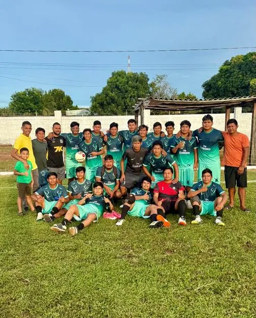 Time adulto de futebol em campo após receber bolas novas.