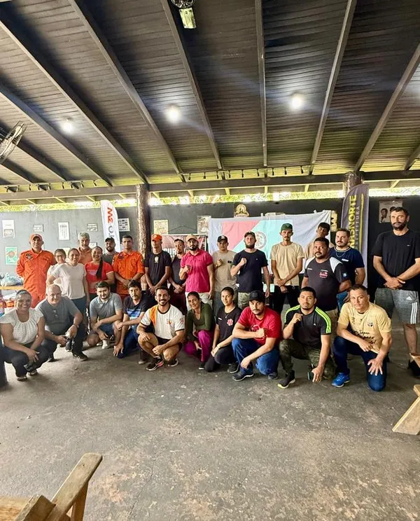 Turma do curso de brigadista reunida em um galpão.