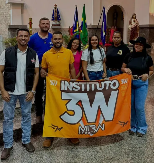 Integrantes do Instituto 3W sorrindo e segurando uma bandeira laranja do instituto.